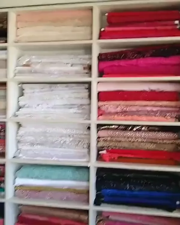 Prateleiras com rolos de tecidos coloridos no ateliê